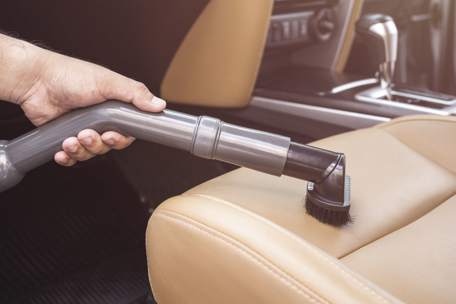 Hand of people holding vacuum cleaner and cleaning inside the SUV car
